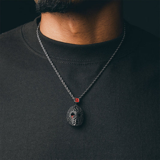 Man wearing the gun metal Eminem hockey mask diamond pendant on a dark chain
