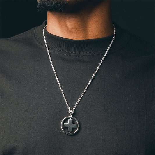 Man wearing the silver Eminem Recovery cross pendant and chain over a black tee