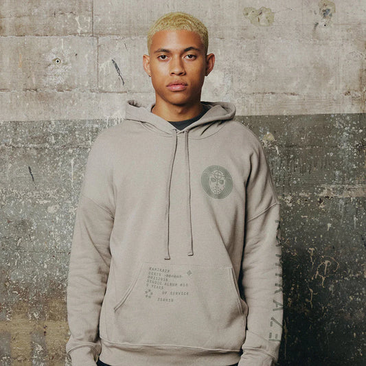 Man wearing the grey Eminem Kamikaze Mask hoodie with tonal chest crest and text