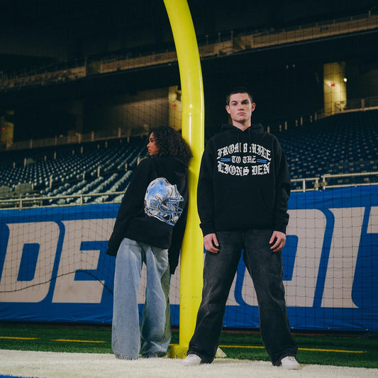 Models in Eminem x Detroit Lions hoodies beside the goal post in an empty stadium