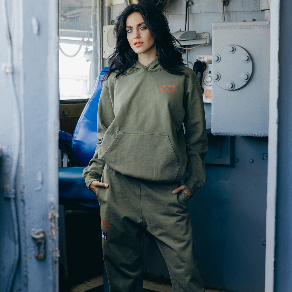 Woman wearing the burnt olive Eminem Kamikaze x Standard Issue hoodie and matching joggers
