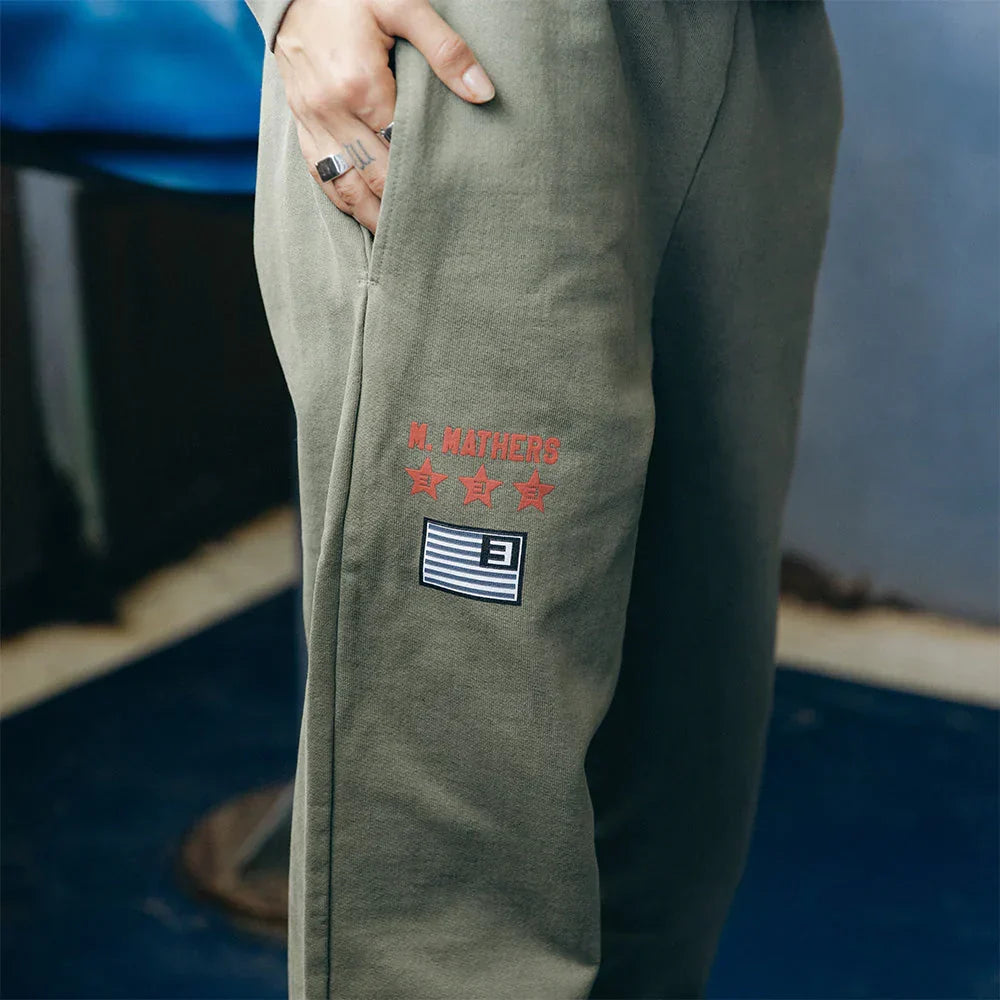 Orange star print and flag patch detail on the burnt olive Eminem Kamikaze sweatpants
