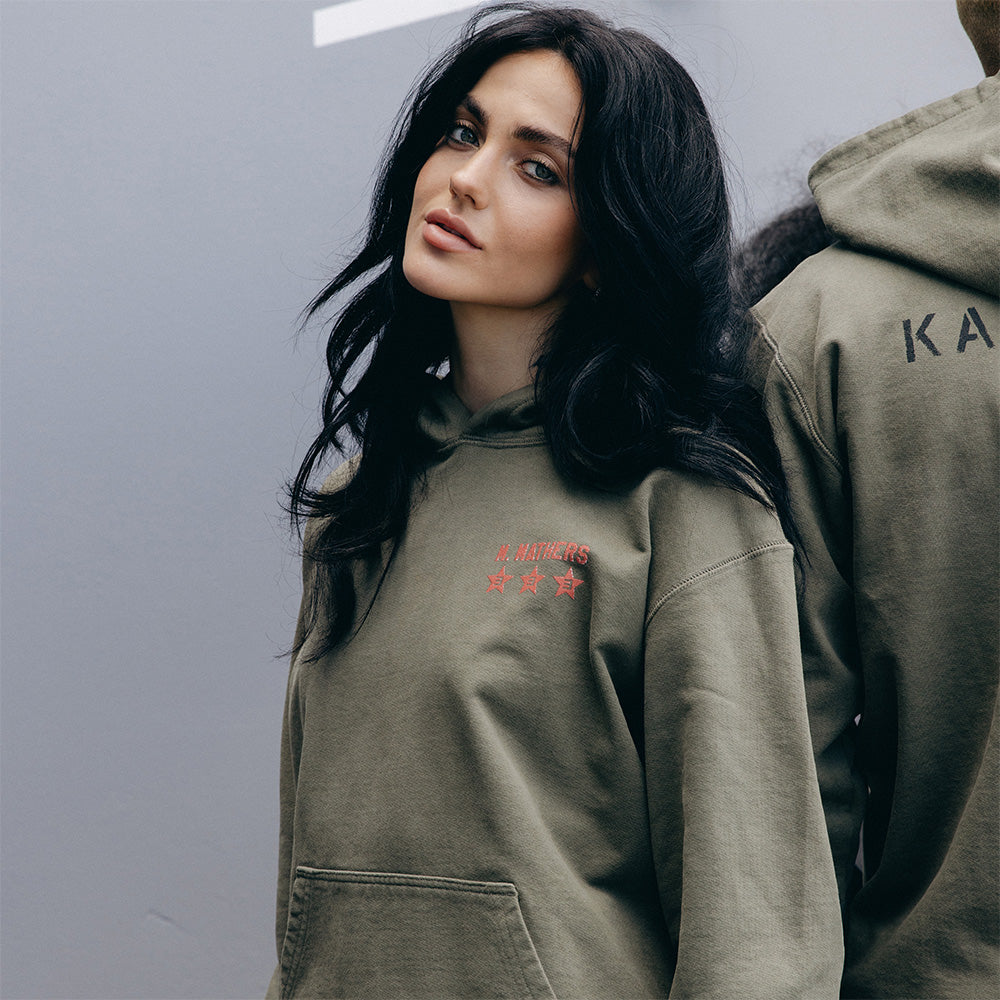 Side view of the burnt olive Eminem Kamikaze x Standard Issue hoodie on a model