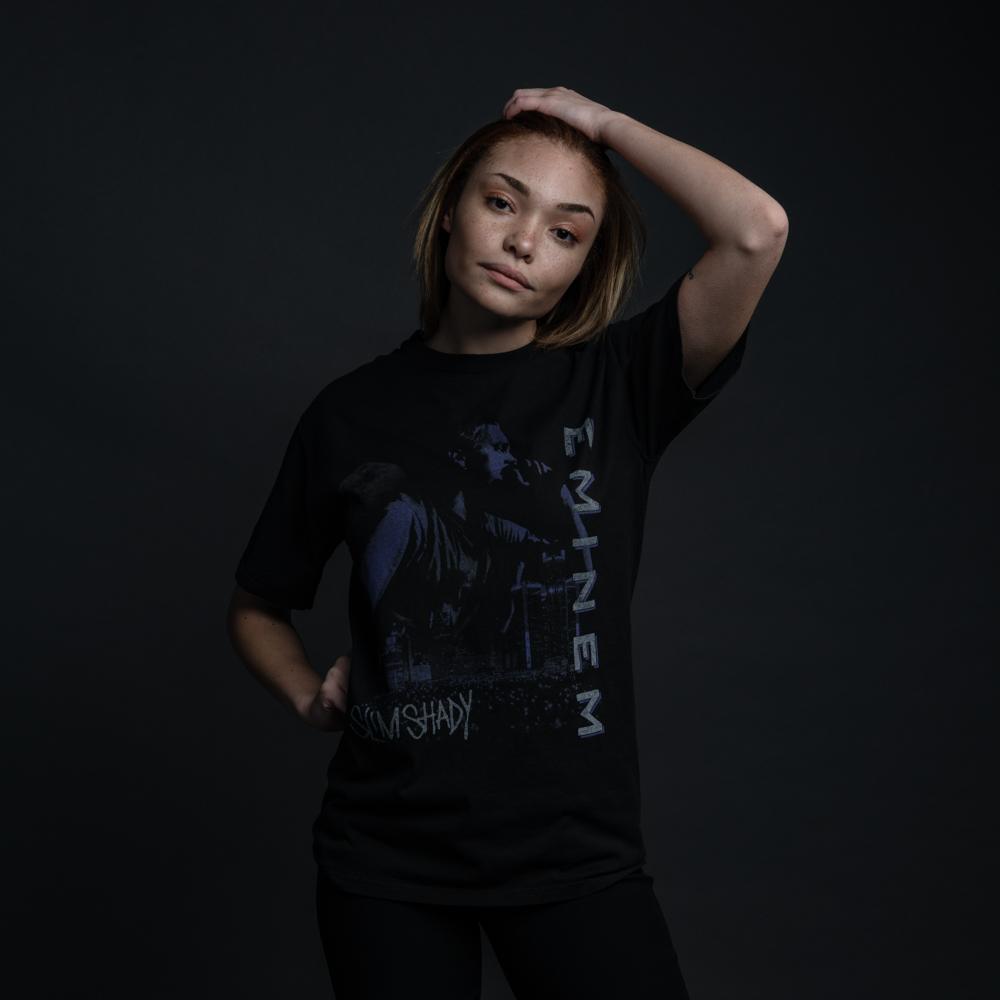 Woman wearing the black Eminem Throwback To '99 T-shirt with vertical logo print