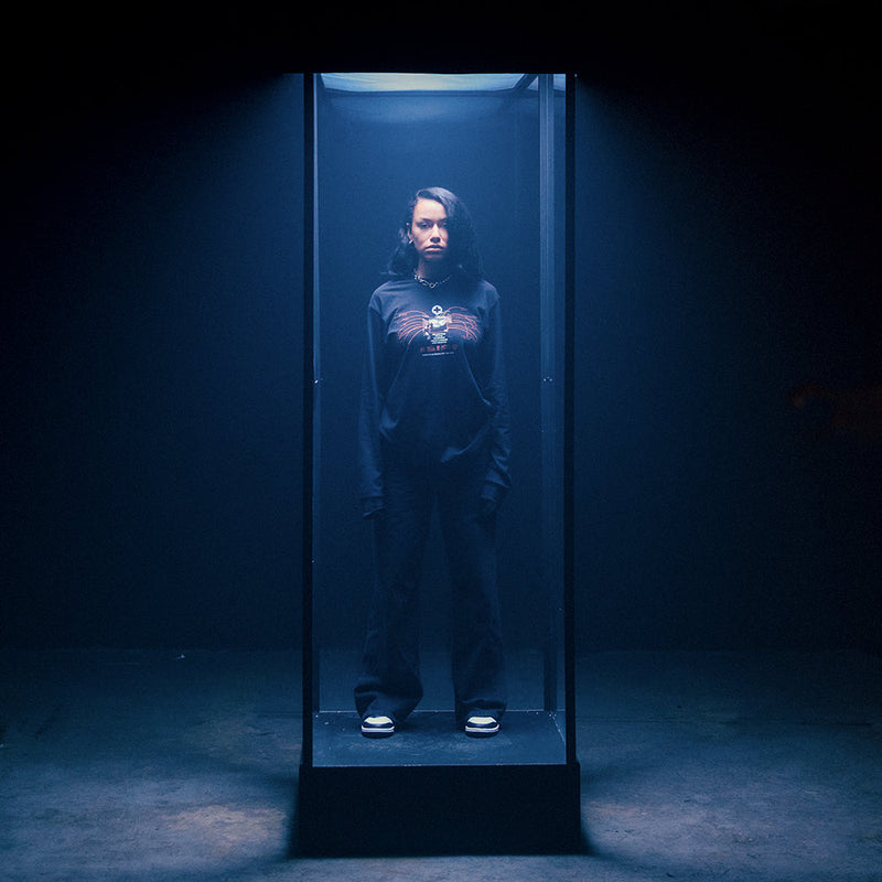 Full-length view of the black Eminem Recovery Tracklist long sleeve under blue light