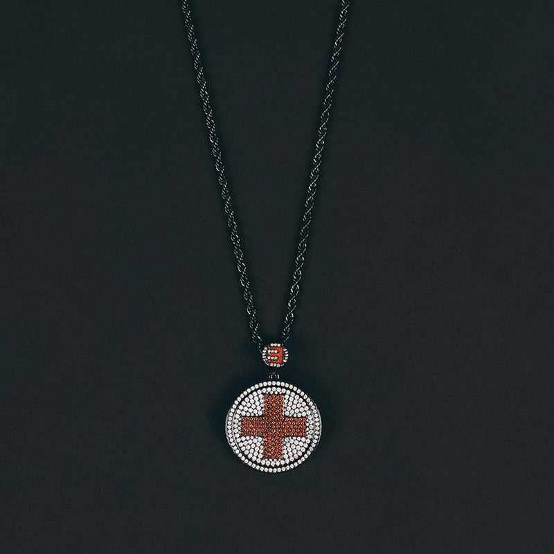 Close-up of the Eminem Recovery diamond pendant with red cross and pave stone setting