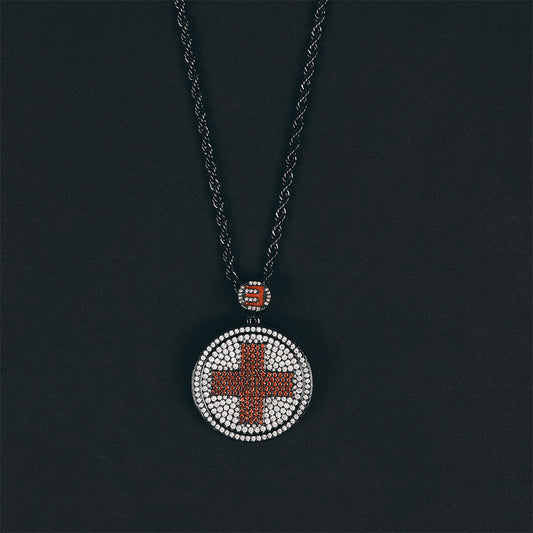 Eminem Recovery diamond cross pendant on a dark chain against a black background