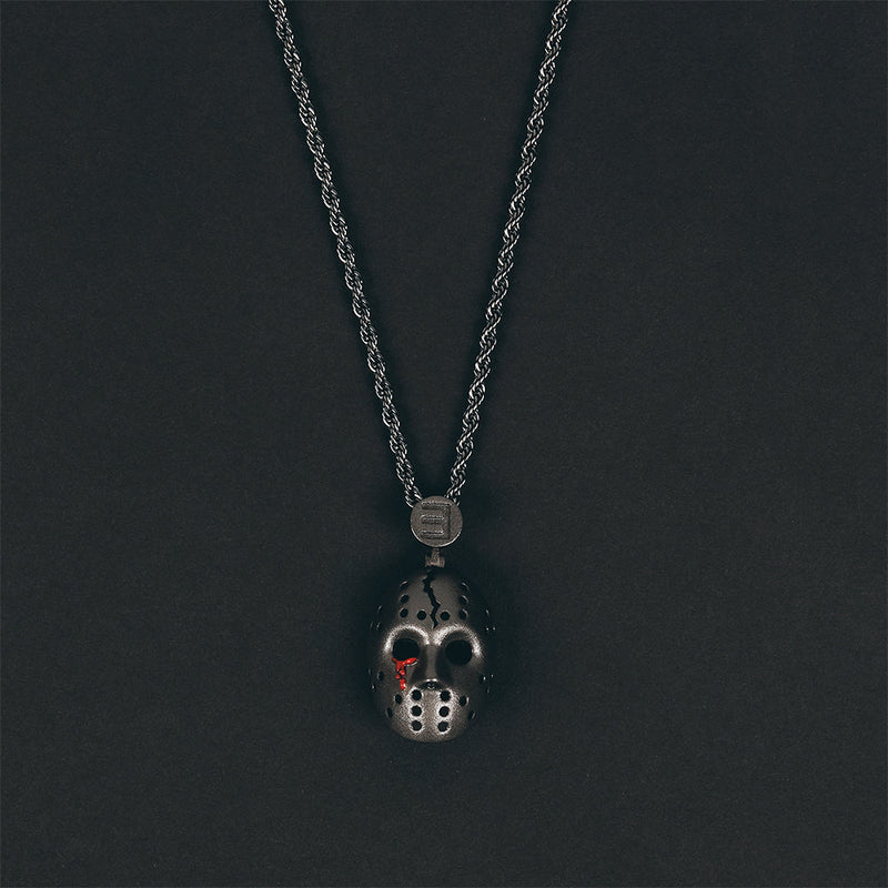 Eminem hockey mask pendant and chain photographed on a dark grey background