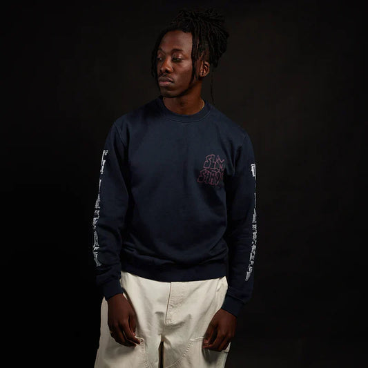 Man wearing the navy Eminem Graffiti Slim crewneck with sleeve lettering
