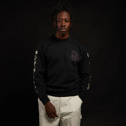 Man wearing the black Eminem Graffiti Slim crewneck with small chest print and sleeve text