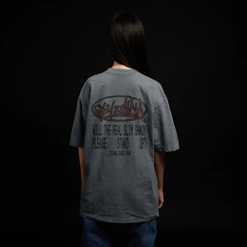 Back of the grey Eminem Plz Stand T-shirt worn by a model, graffiti and stencil text