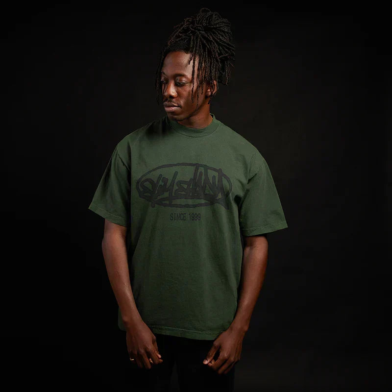 Man wearing the green Eminem Plz Stand T-shirt with graffiti Slim Shady chest print