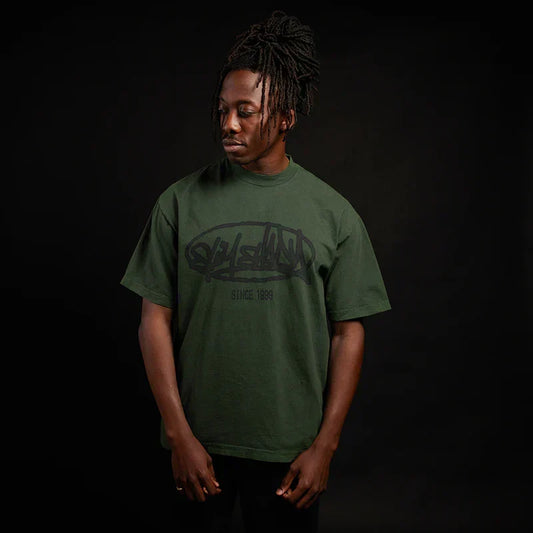 Man wearing the green Eminem Plz Stand T-shirt with graffiti Slim Shady chest print