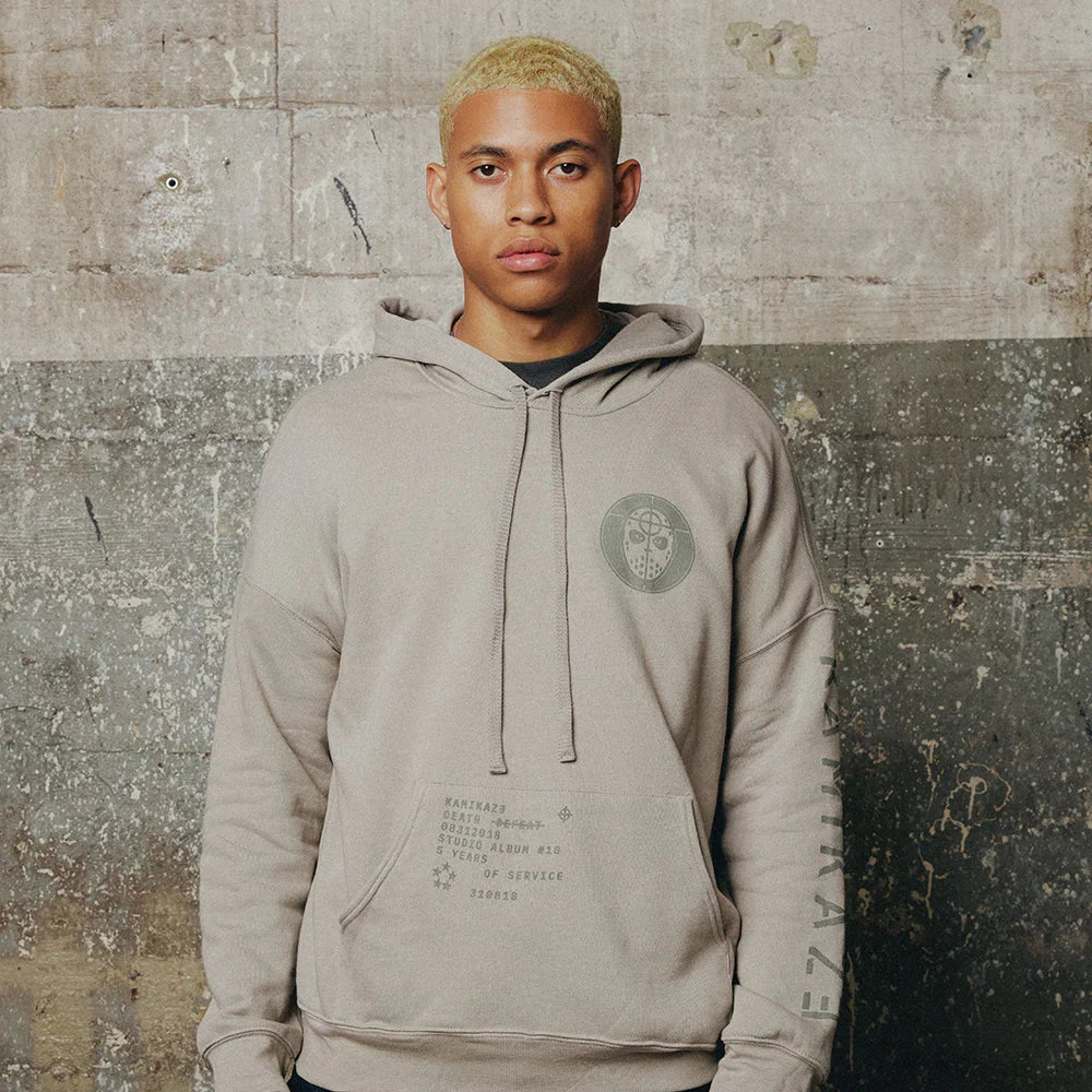 Man wearing the grey Eminem Kamikaze Mask hoodie with tonal chest crest and text