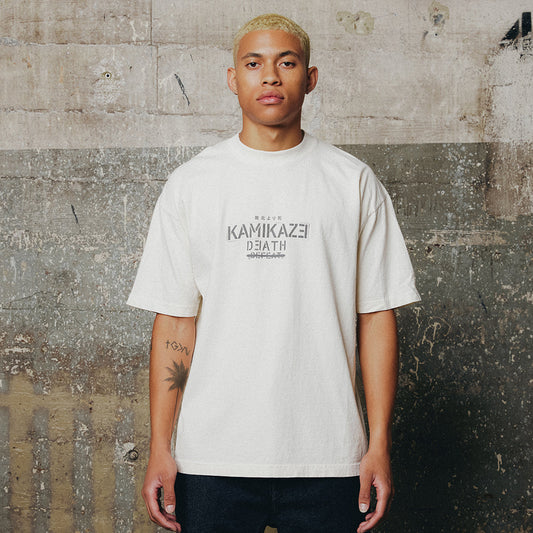 Man wearing the cream Eminem Kamikaze Propaganda T-shirt with tonal chest print