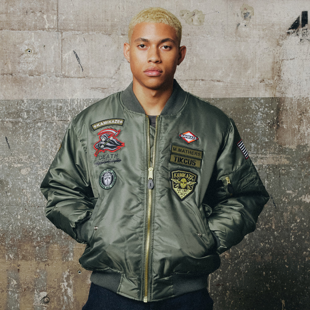 Man wearing the green Eminem Kamikaze Pilot bomber jacket with embroidered patches