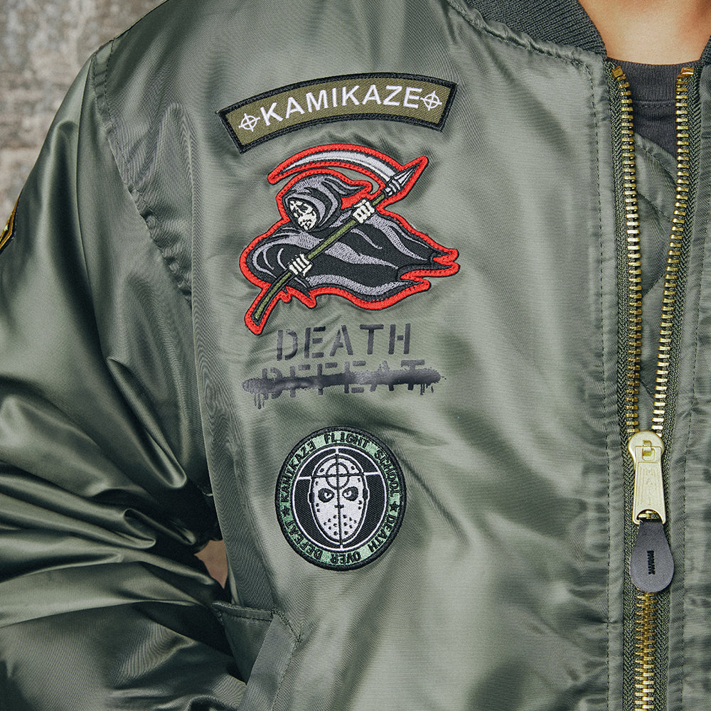 Embroidered reaper patch detail on the green Eminem Kamikaze Pilot bomber jacket