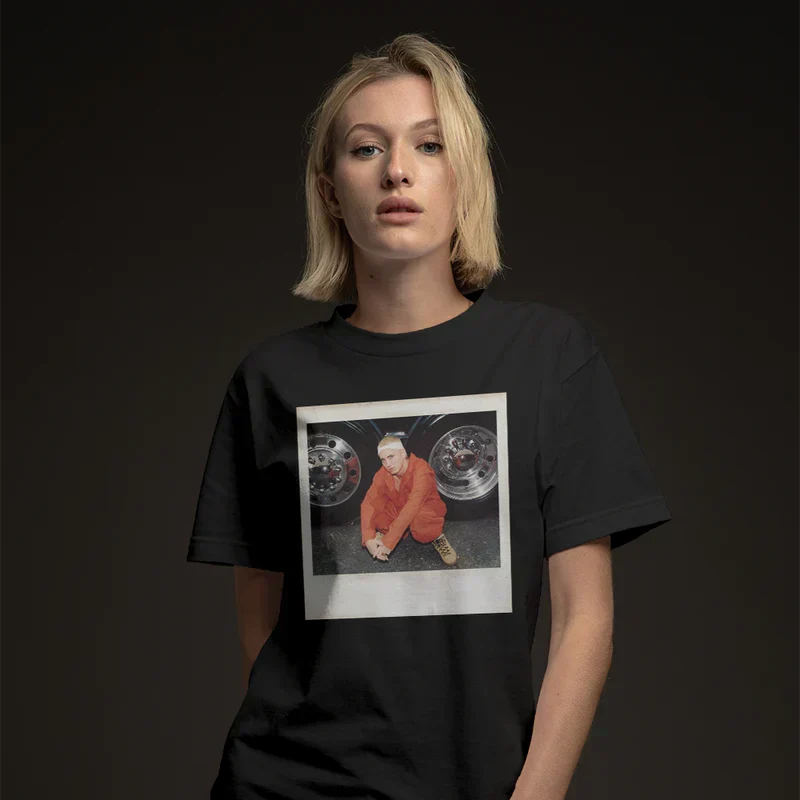 Woman wearing the black Eminem Polaroid T-shirt with framed orange jumpsuit photo