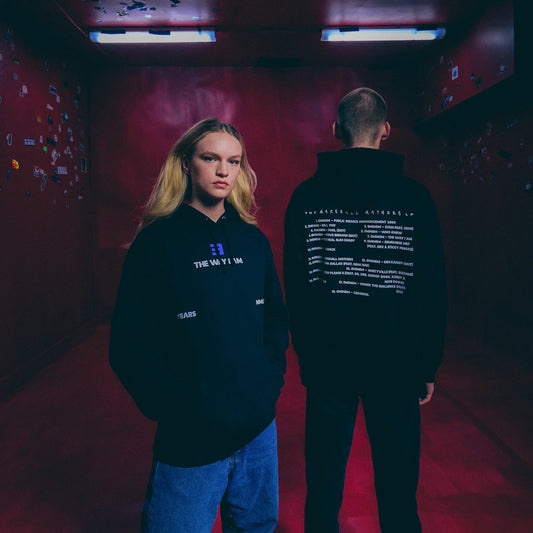 Two models in black Eminem MMLP25 hoodies with blue chest print and back text