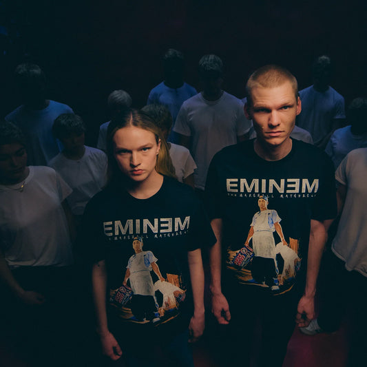 Models wearing black Eminem MMLP25 Tracklist T-shirts in a crowd scene