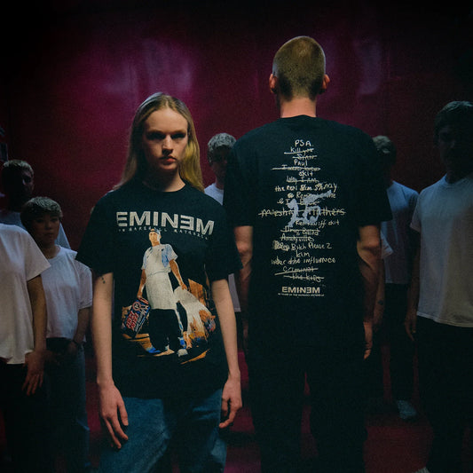 Two models in black Eminem MMLP25 Tracklist T-shirts with front photo and back list prints