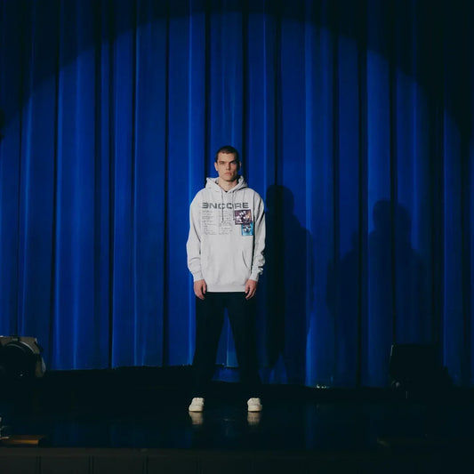 Full-length shot of the grey Eminem Encore 20th Anniversary hoodie on a blue-lit stage