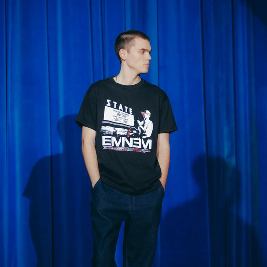 Man wearing the black Eminem Encore 20th Dynamite T-shirt with white Eminem logo