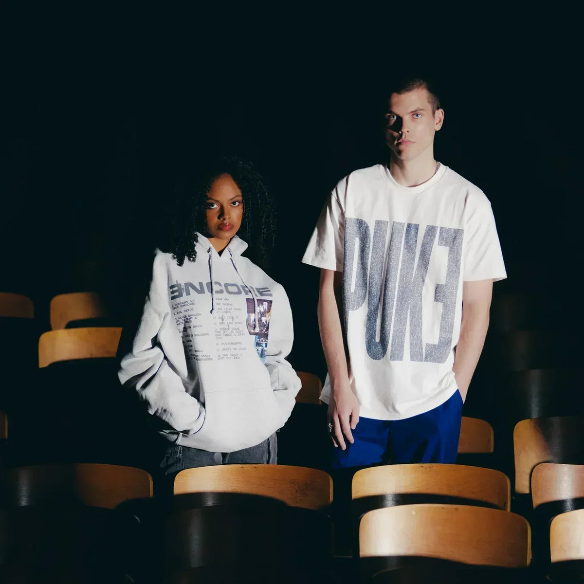 Two models in Eminem Encore PUKE T-shirt and hoodie among theatre seats