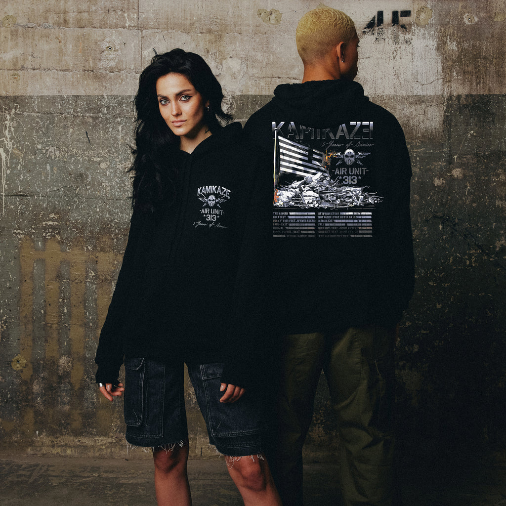 Two models in black Eminem Kamikaze Flag hoodies with white plane graphic back prints