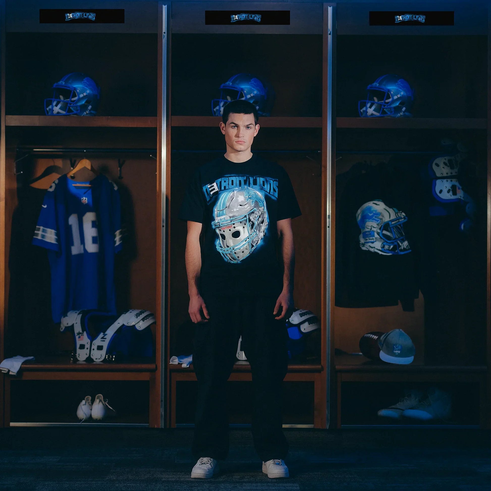 Model in the Eminem x Detroit Lions All Grit T-shirt standing by the locker room stalls