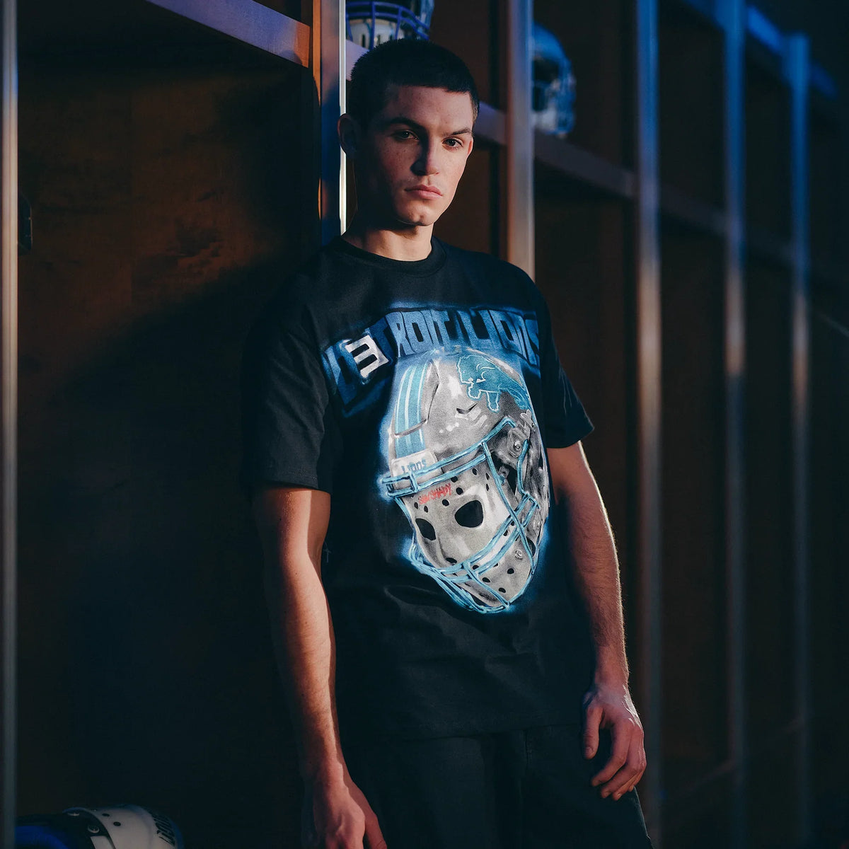 Man wearing the black Eminem x Detroit Lions All Grit T-shirt with chrome helmet print