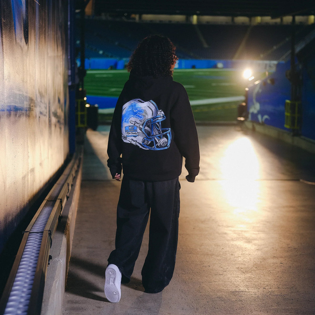 Back view of the Eminem x Detroit Lions Helmet hoodie in the players' tunnel