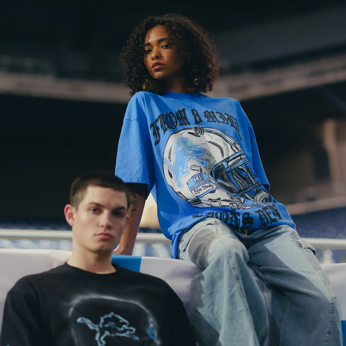 Models in Eminem x Detroit Lions Helmet T-shirt and hoodie in the stadium stands