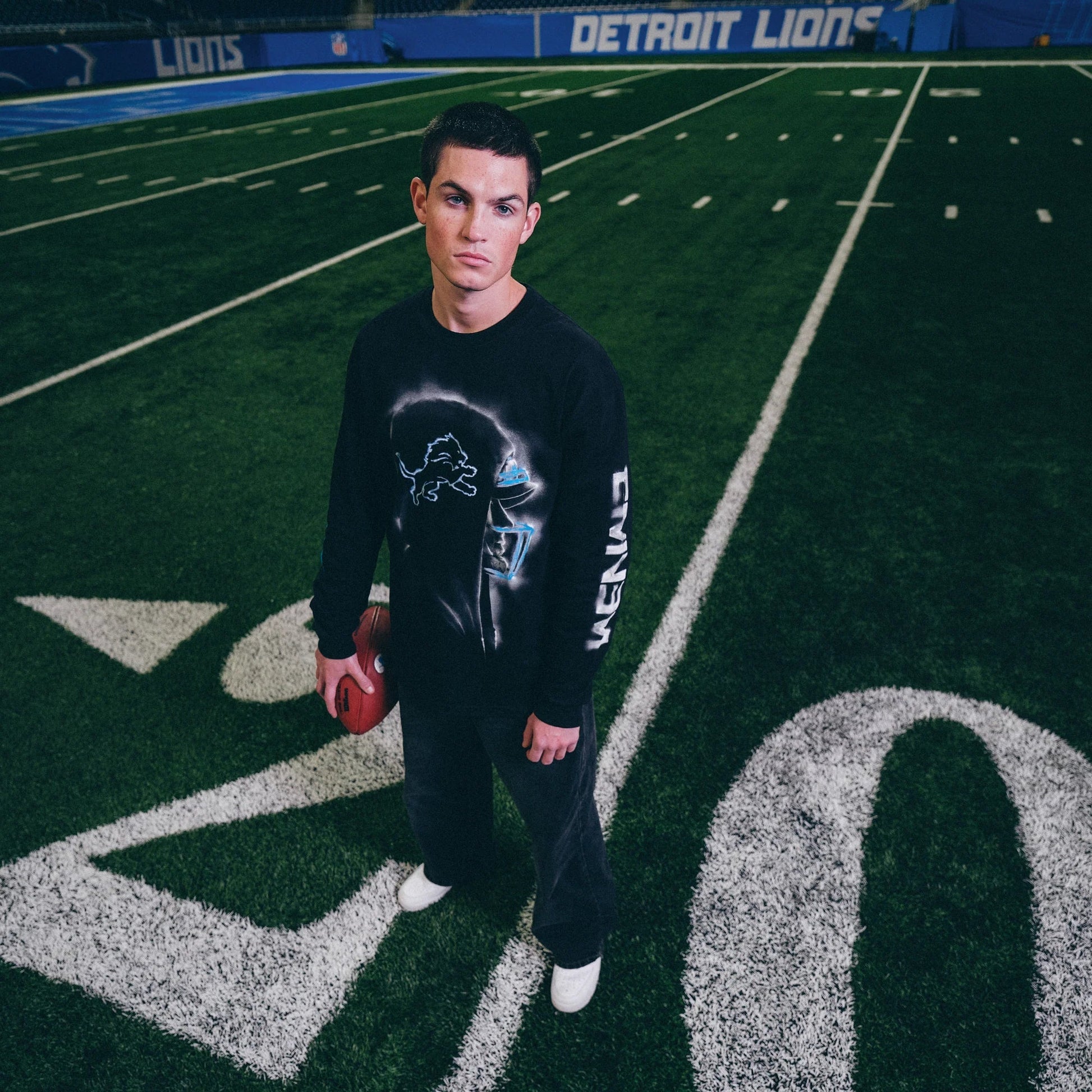 Model in the Eminem x Detroit Lions Silhouette long sleeve shirt on the twenty yard line