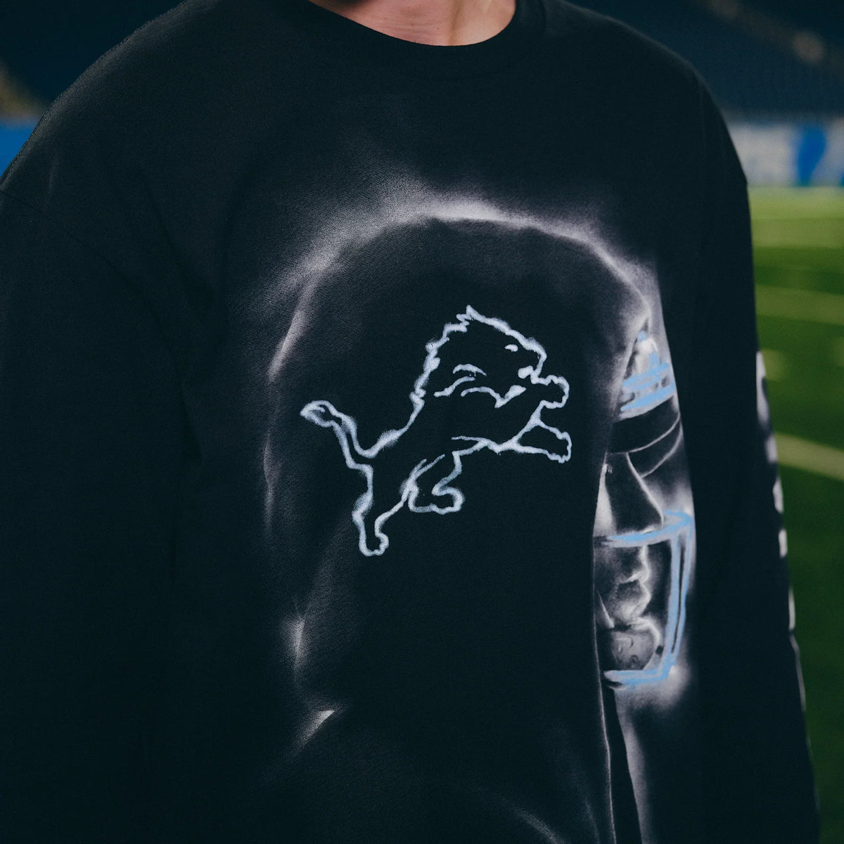 Close-up of the Lions logo and Eminem silhouette print on the black long sleeve shirt