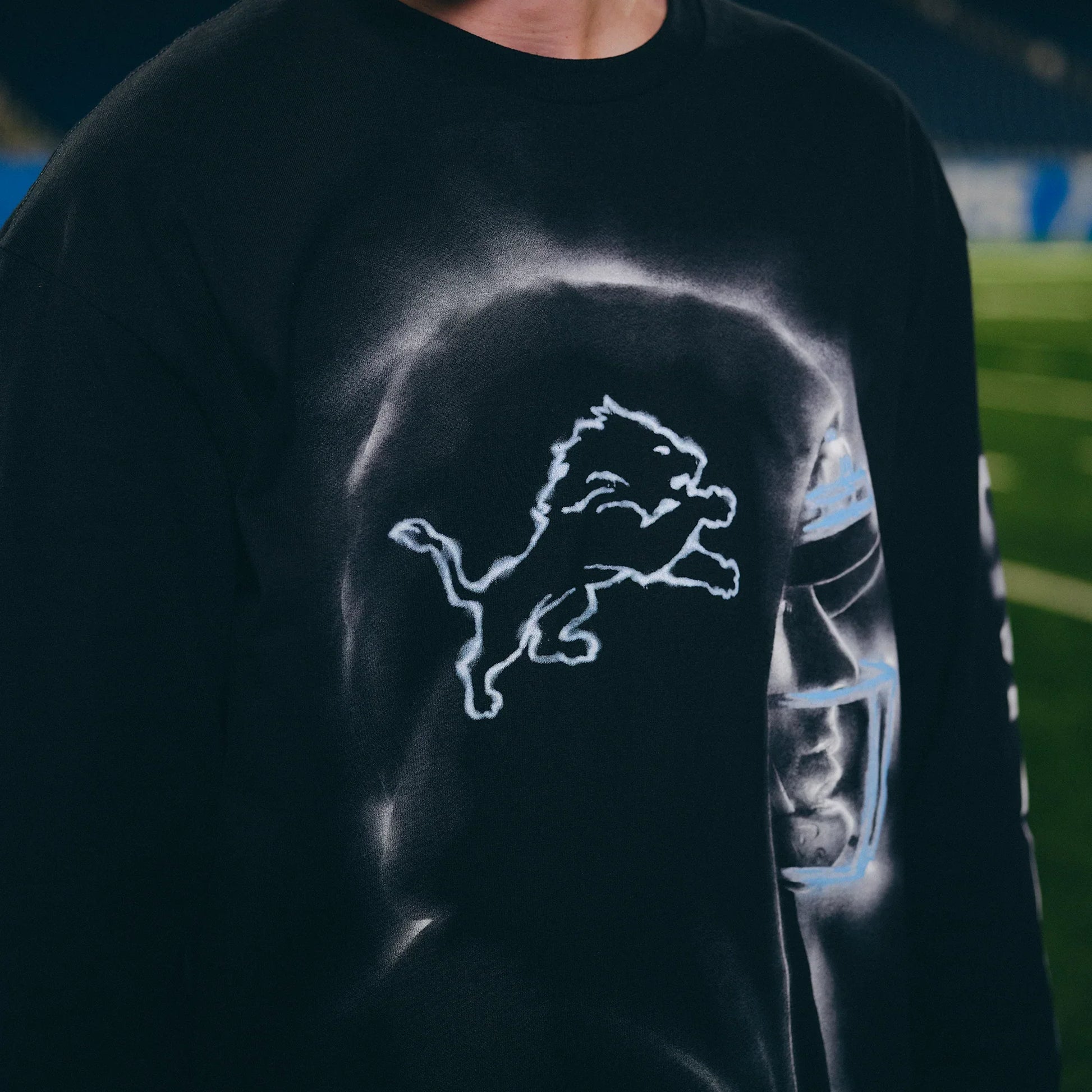 Close-up of the Lions logo and Eminem silhouette print on the black long sleeve shirt