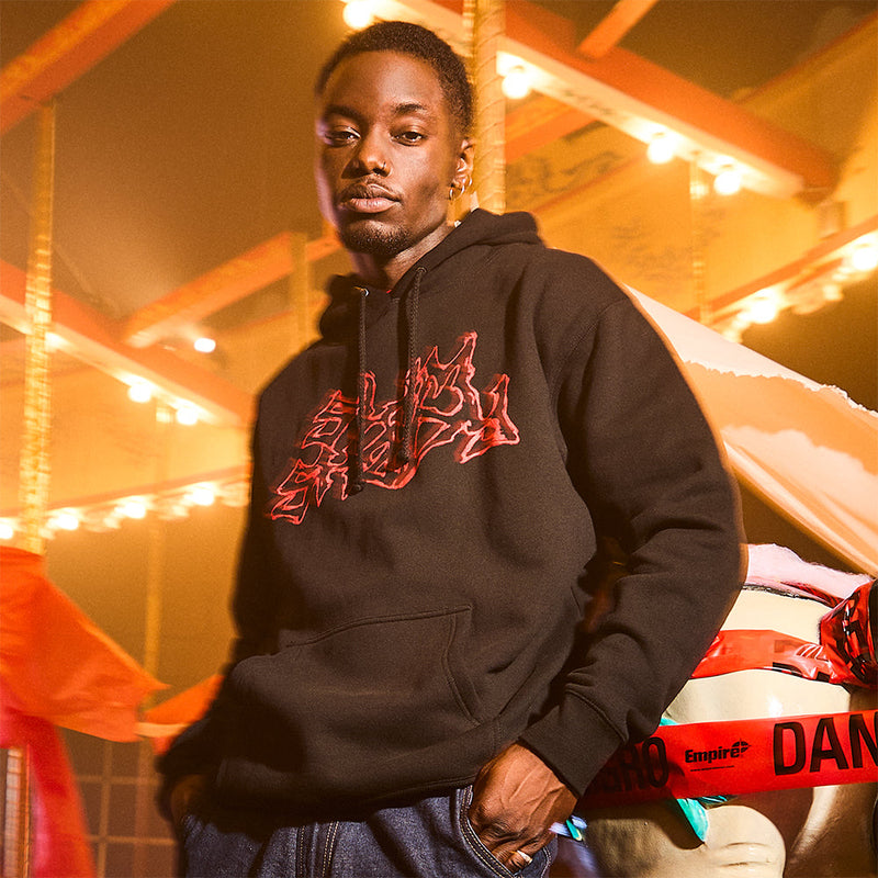 Man wearing the brown Eminem Massacre hoodie with red dripping chest graphic