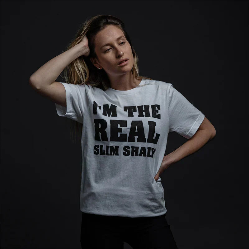 Woman wearing the white Eminem I'm The Real Slim Shady T-shirt with bold black type