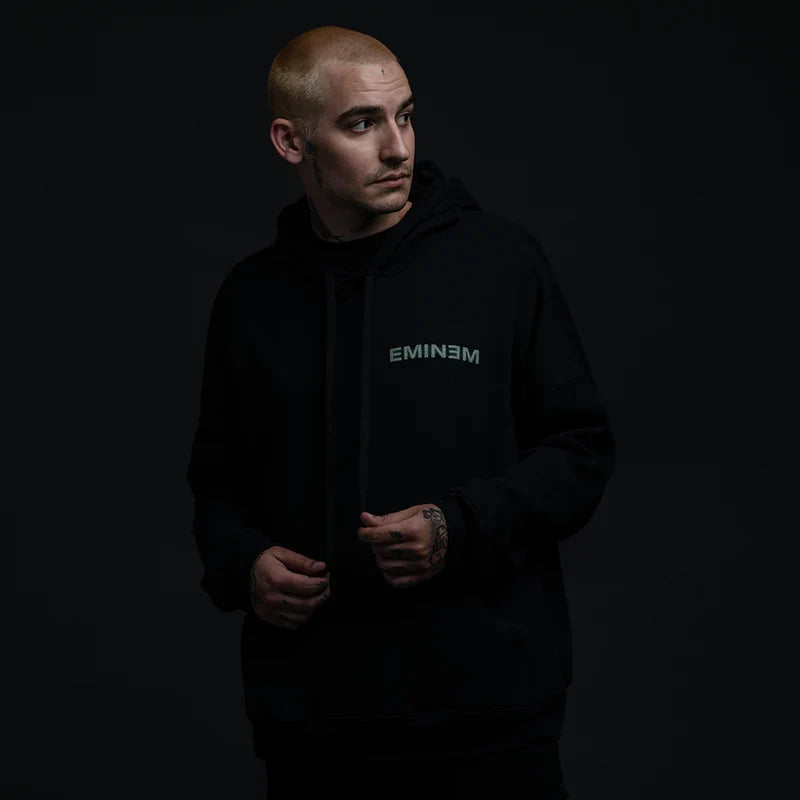 Man wearing the black Eminem Orange Jumpsuit hoodie with small chest lettering