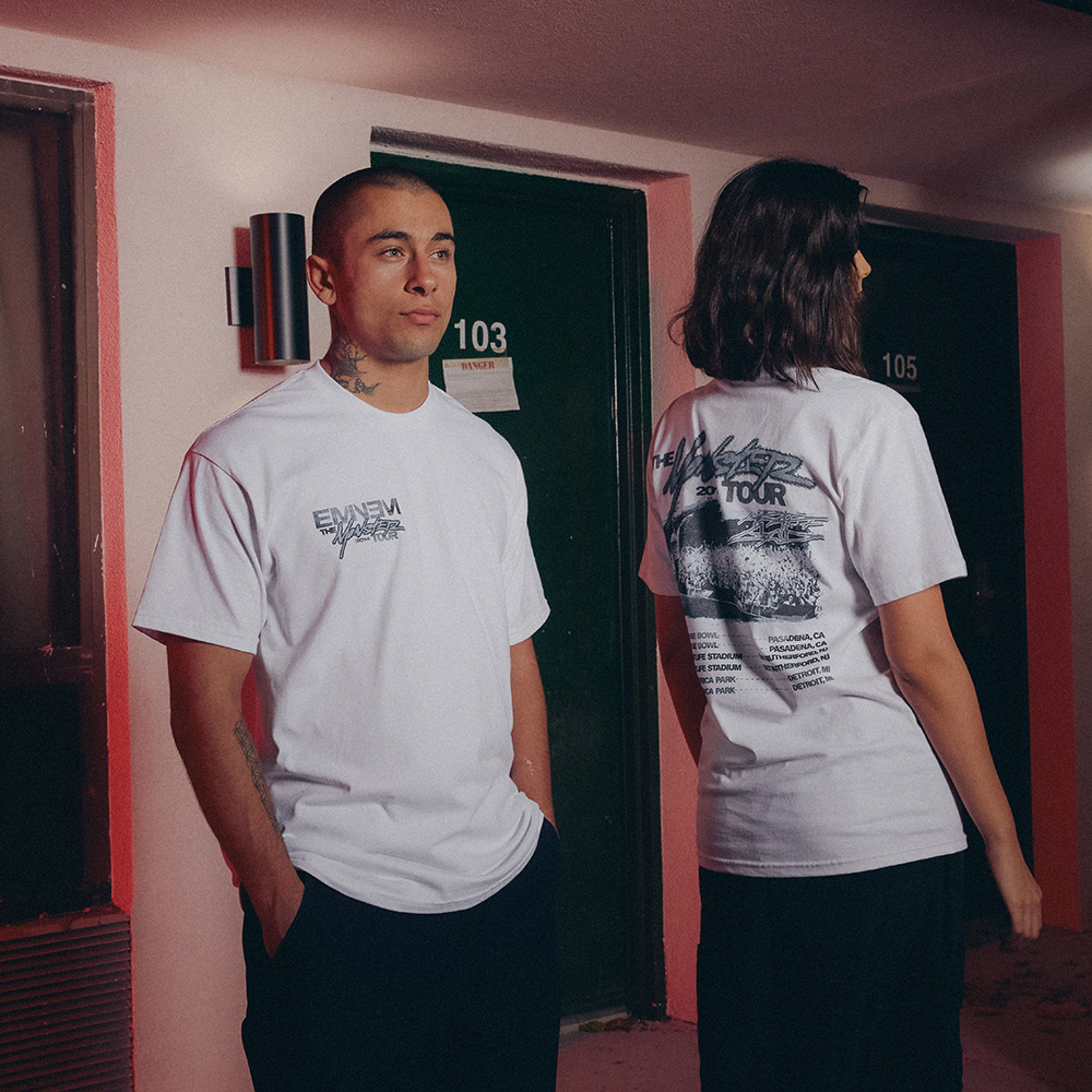 Two models in white Eminem MMLP2 Monster Tour T-shirts in a motel corridor