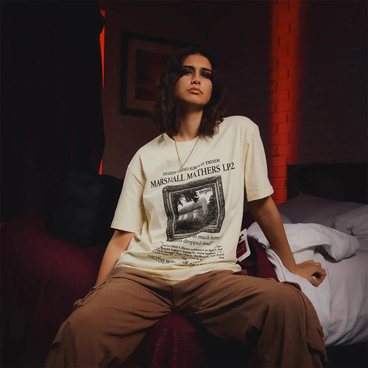 Woman wearing the cream Eminem MMLP2 album T-shirt with house photo artwork