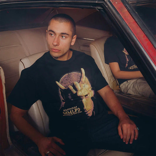 Man wearing the black Eminem MMLP2 Horns T-shirt with gold horned portrait print