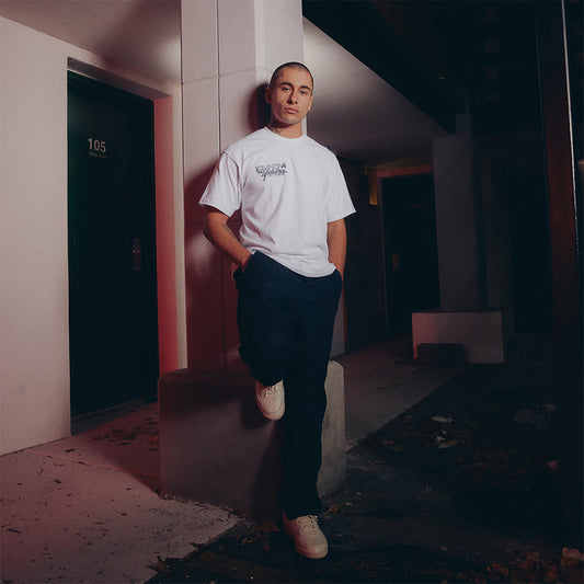 Man wearing the white Eminem MMLP2 Monster Tour T-shirt, front logo print