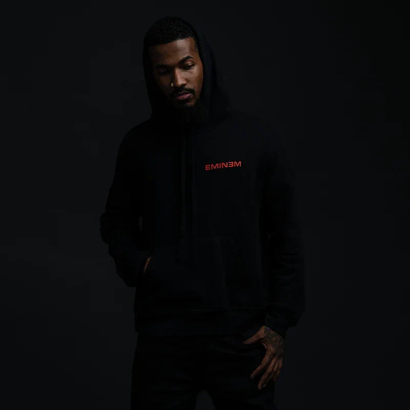 Man wearing the black Eminem Powerline hoodie with small red chest lettering
