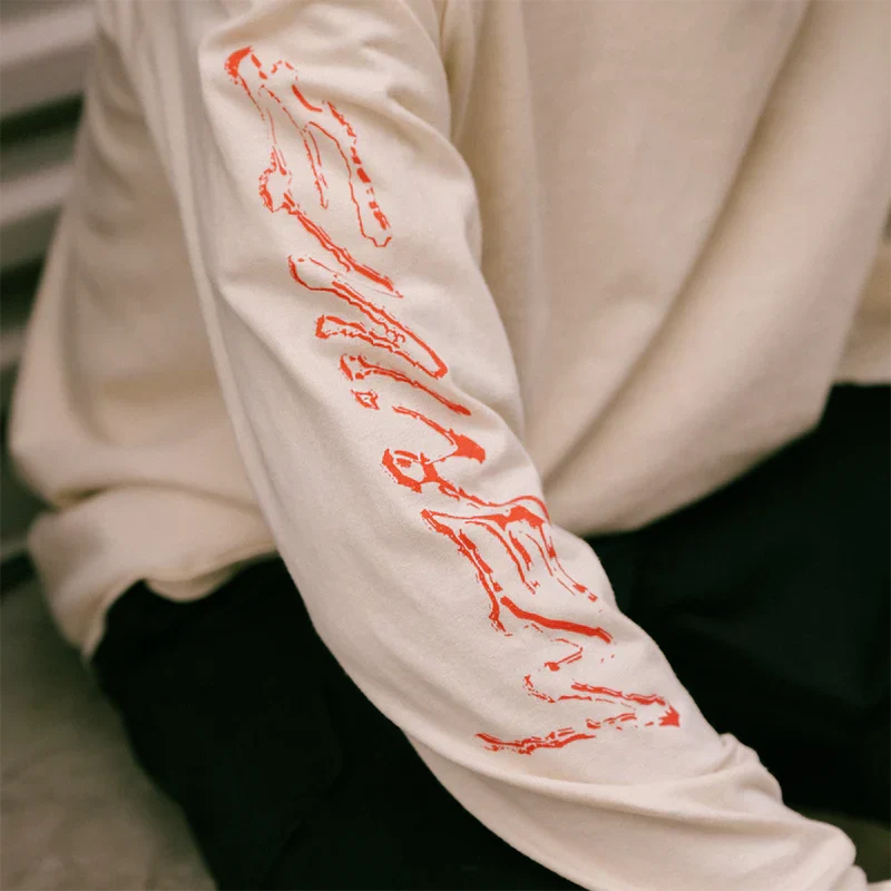 Sleeve detail of the cream Eminem Recovery long sleeve with red graffiti lettering