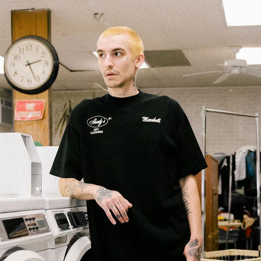 Man wearing the black Eminem Shady Cleaners T-shirt with Shady's Dry Cleaning prints