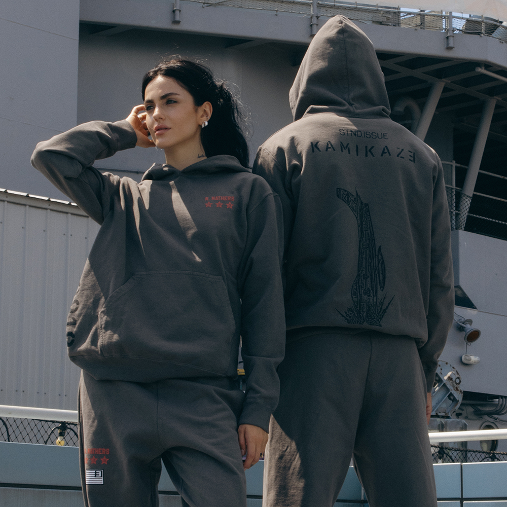 Two models in taupe Eminem Kamikaze x Standard Issue hoodies on a ship deck