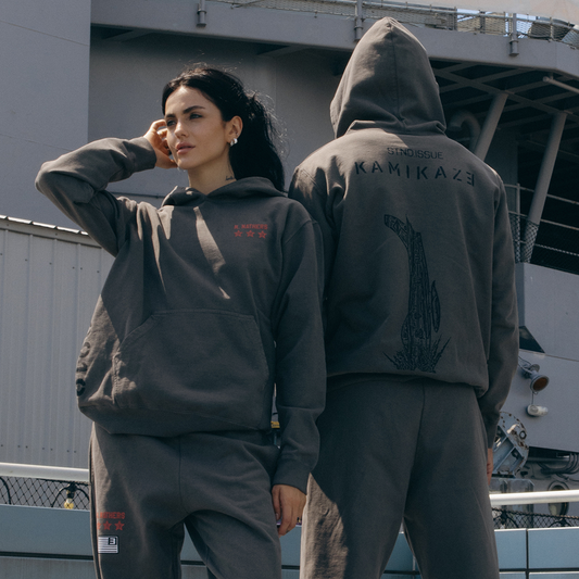 Two models in taupe Eminem Kamikaze x Standard Issue hoodies on a ship deck