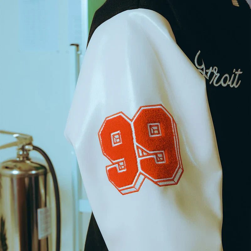 Sleeve detail of the Eminem SSLP25 varsity jacket with red chenille 99 patch