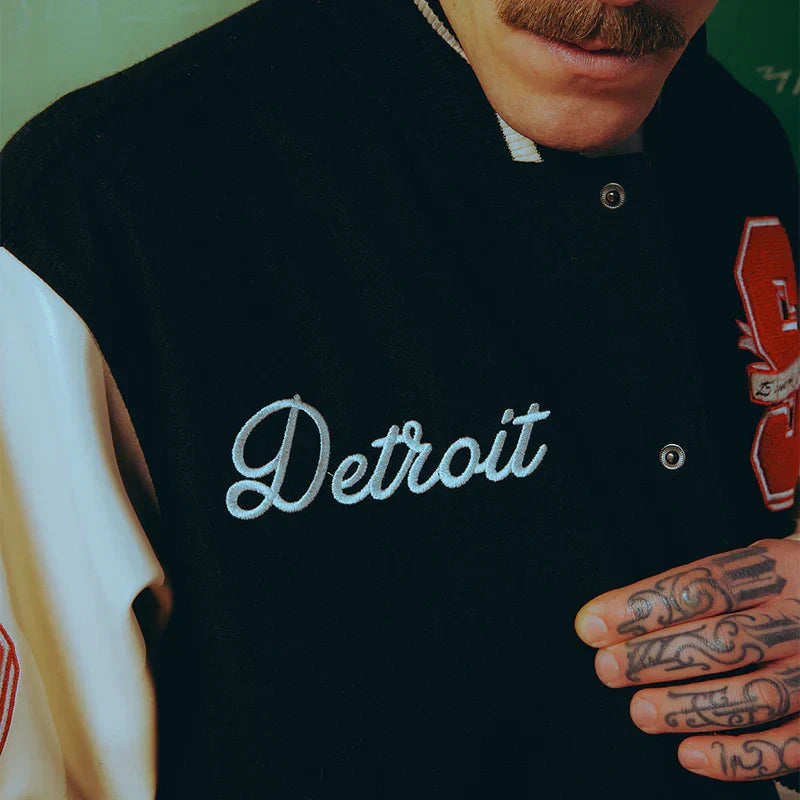 Chest detail of the Eminem SSLP25 varsity jacket with Detroit chain-stitch script